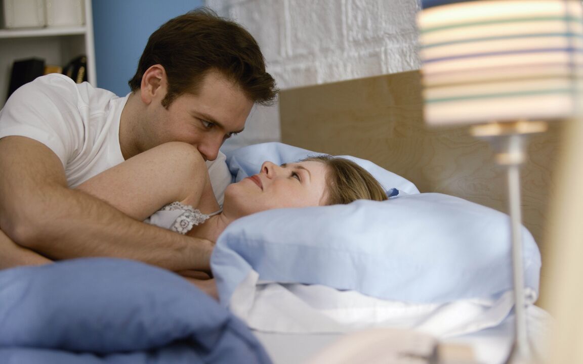 Woman in bed with man with penis enlargement